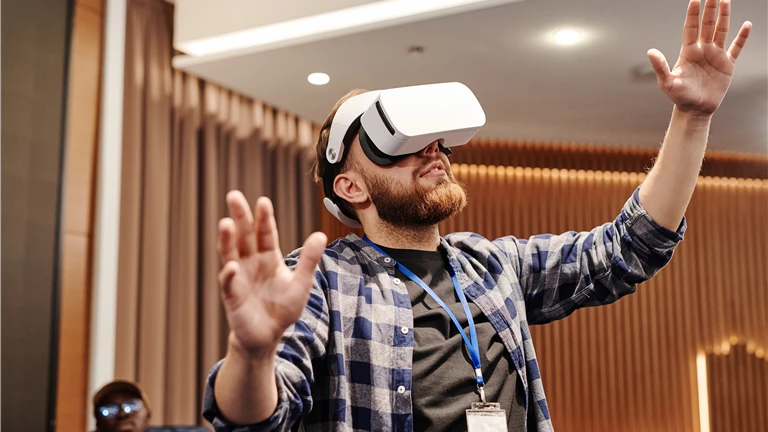 Man Wearing Virtual Reality Headset Raising His Hands
