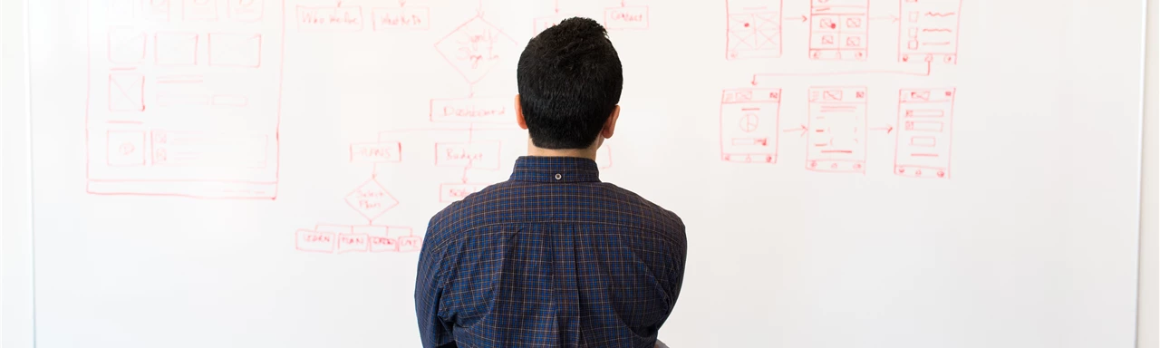 Man Standing Infront of White Board