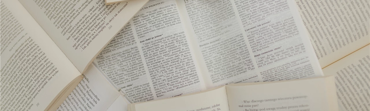 From above of opened books with white pages placed above each other in library