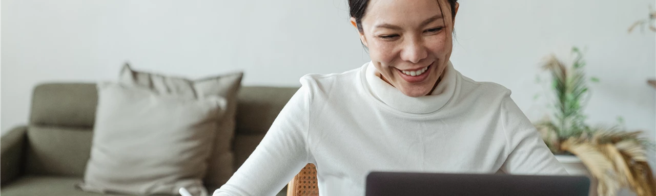 Woman working at home and making video call on laptop