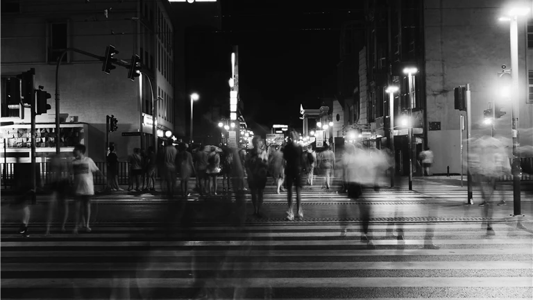 Group of People Crossing Pedestrian Lane in Greyscale